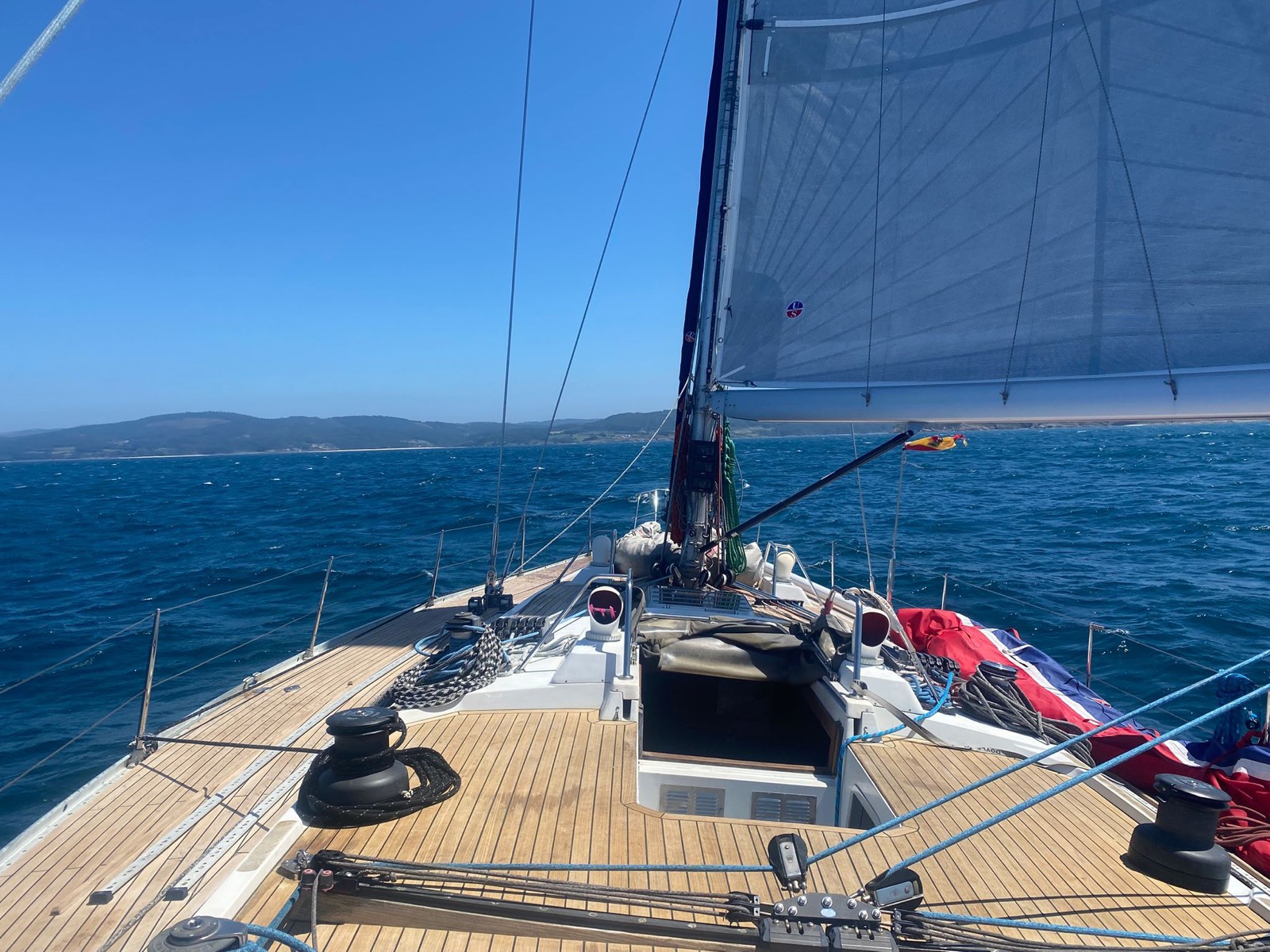 SY Cormorant's teak foredeck under sail along the coast